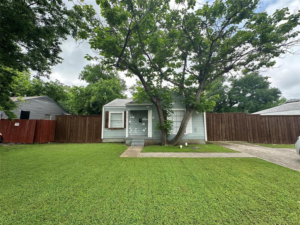 a view of a house with a yard and large trees