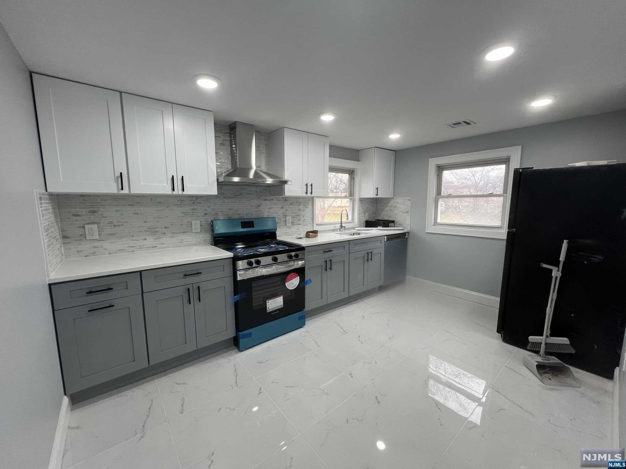 a kitchen with granite countertop a sink stainless steel appliances and cabinets