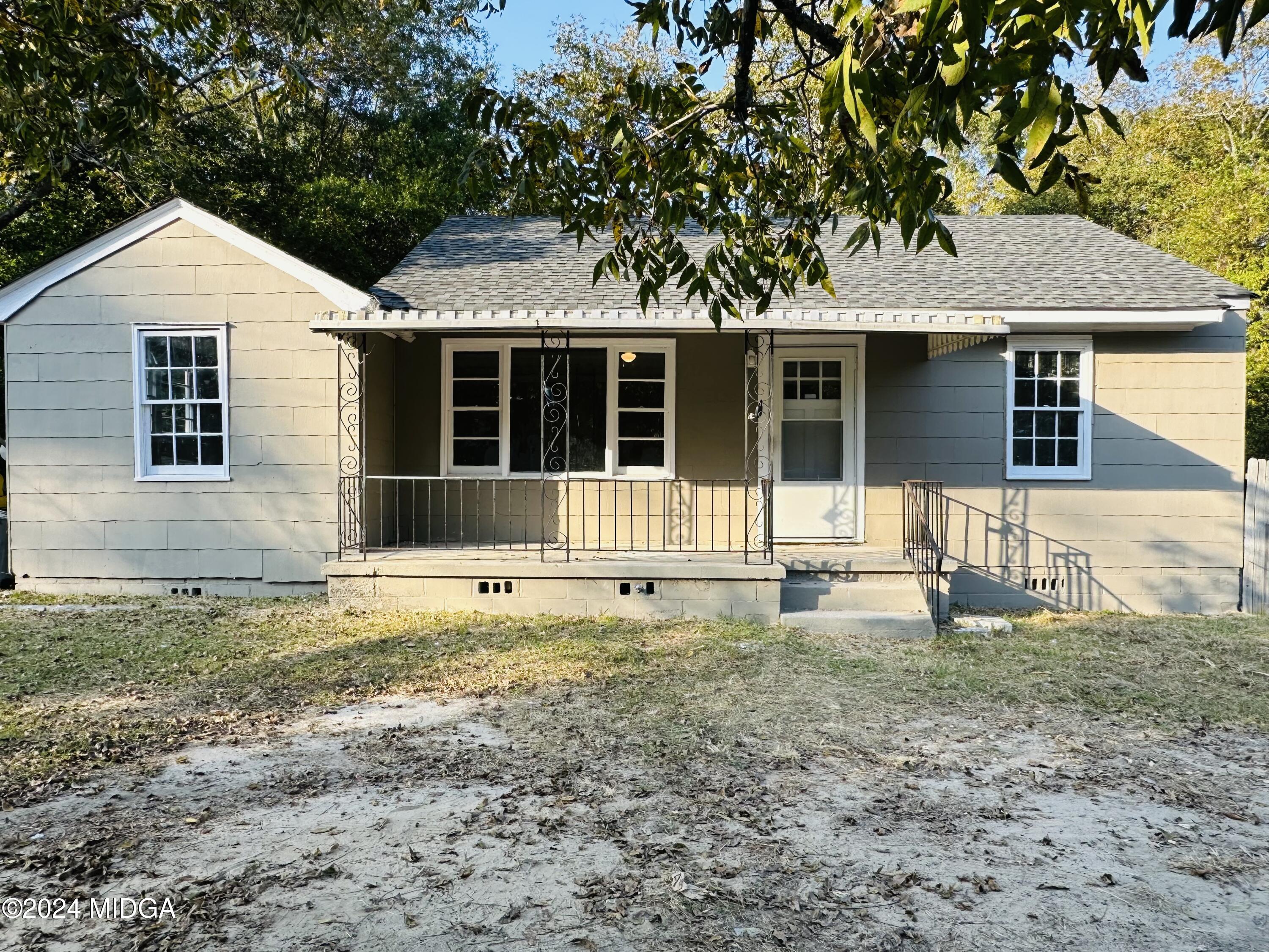 a front view of a house with a garden and yard