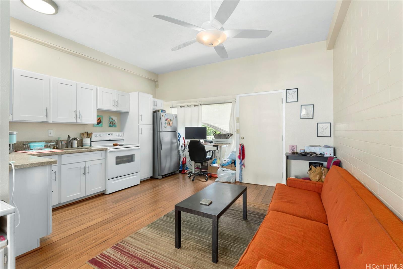 a view of a living room with furniture and a kitchen view