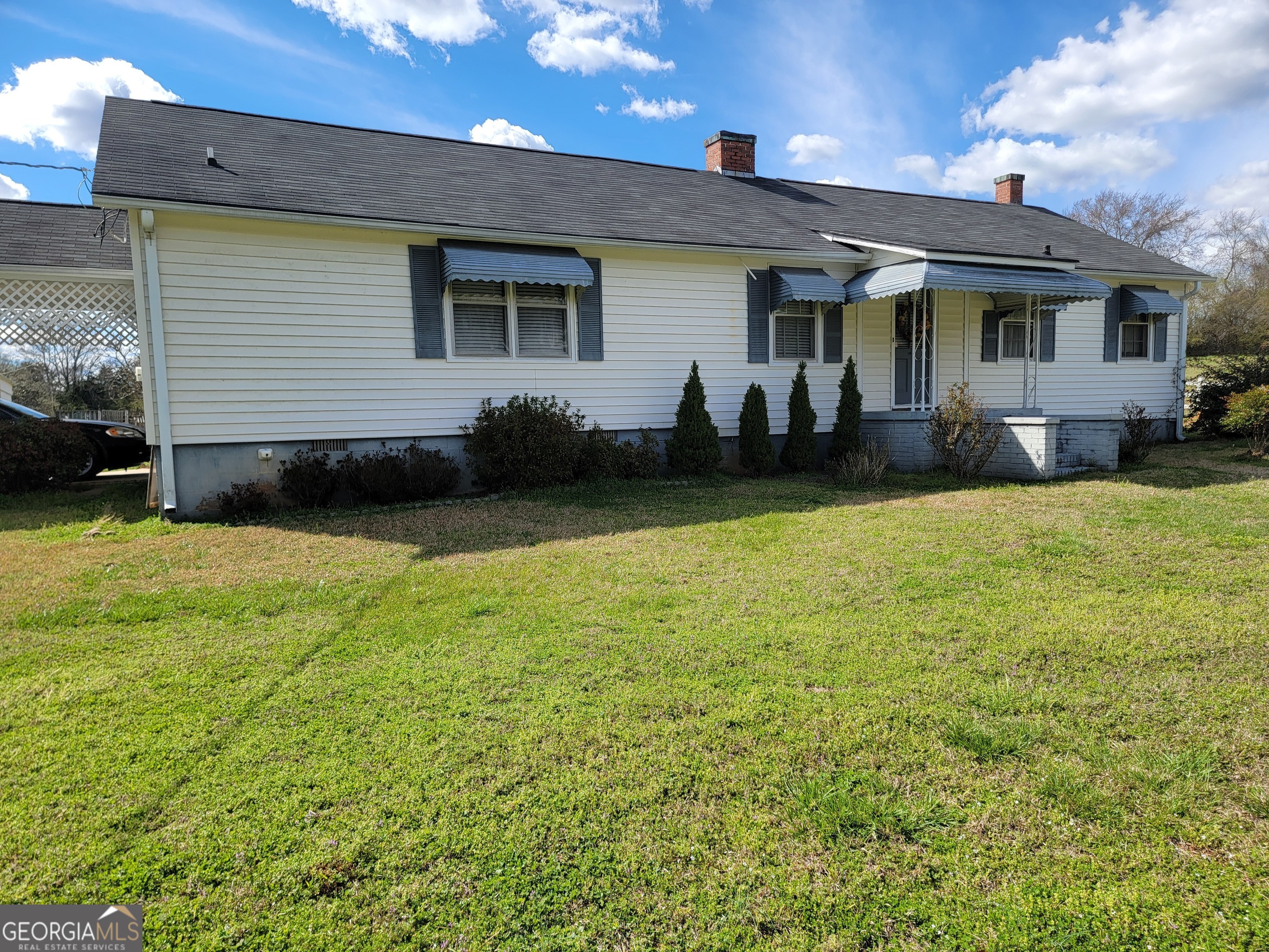 a view of a house with backyard and sitting area