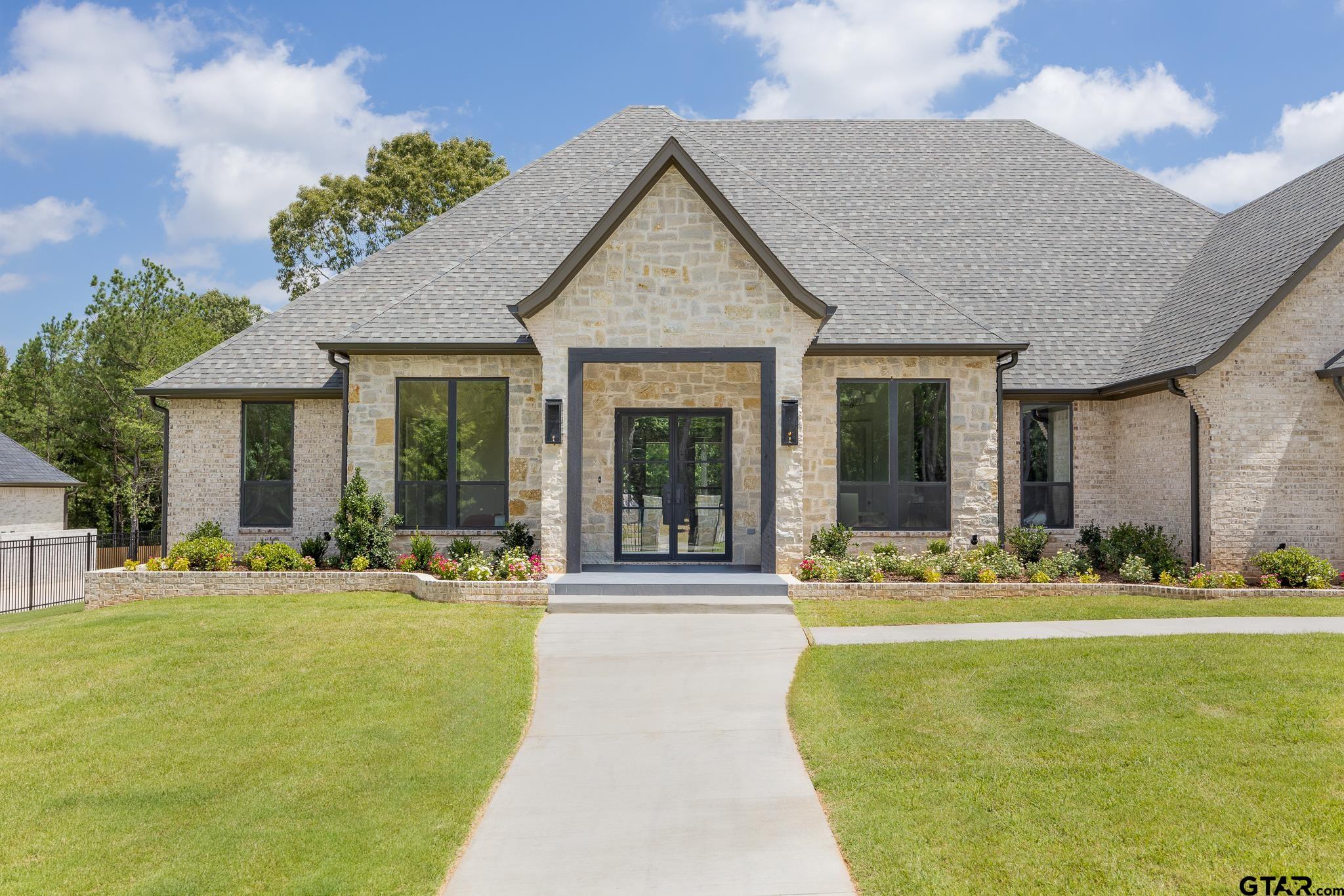 a front view of a house with a garden and patio