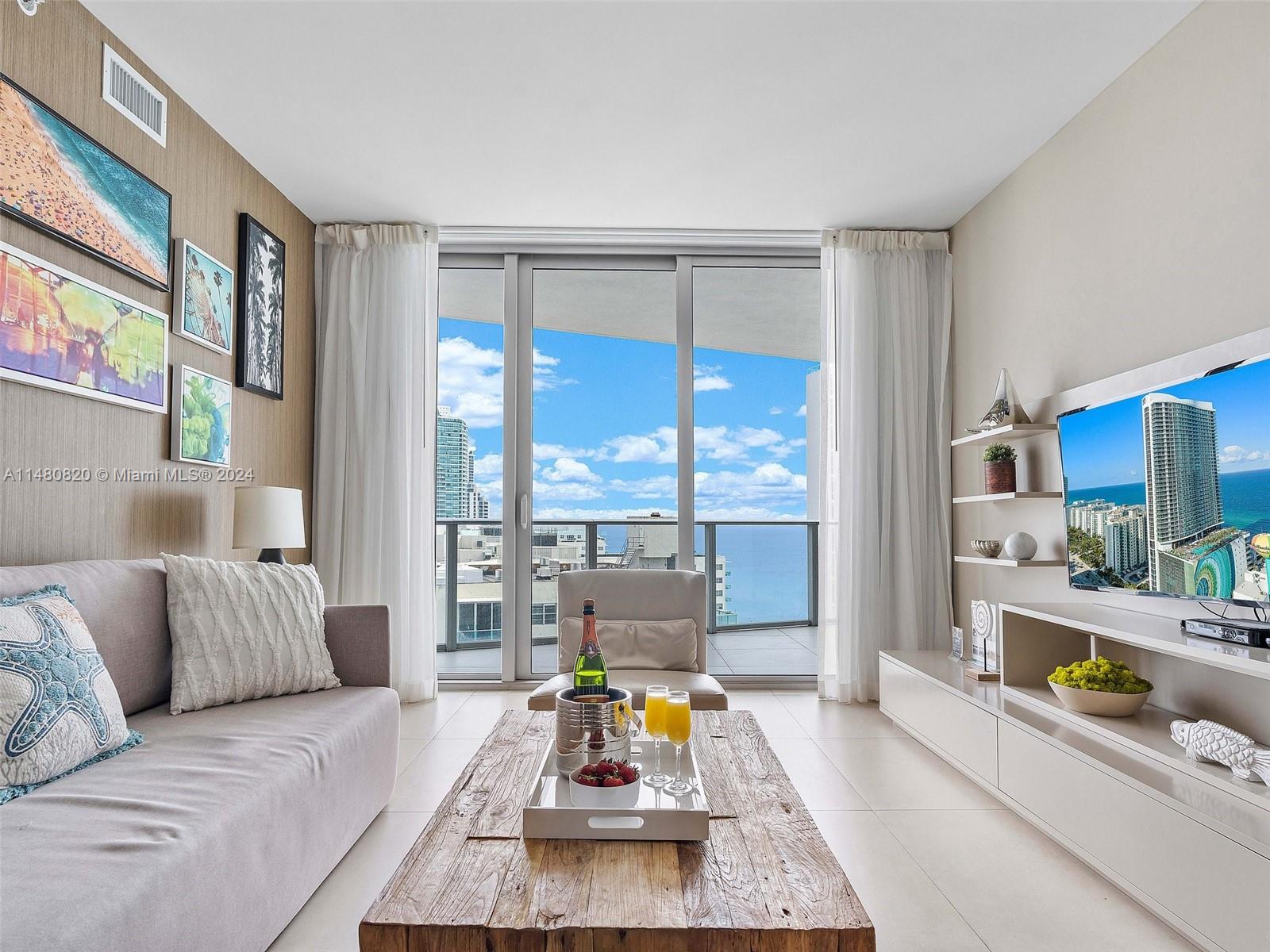 a living room with furniture and floor to ceiling windows