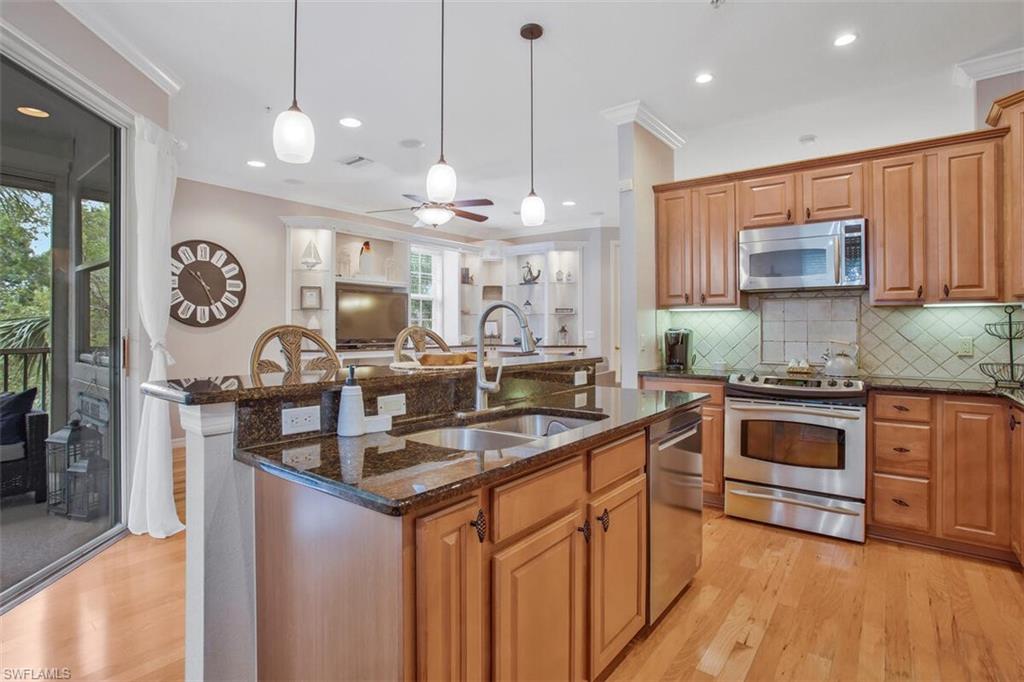 a kitchen with stainless steel appliances granite countertop a sink stove and refrigerator