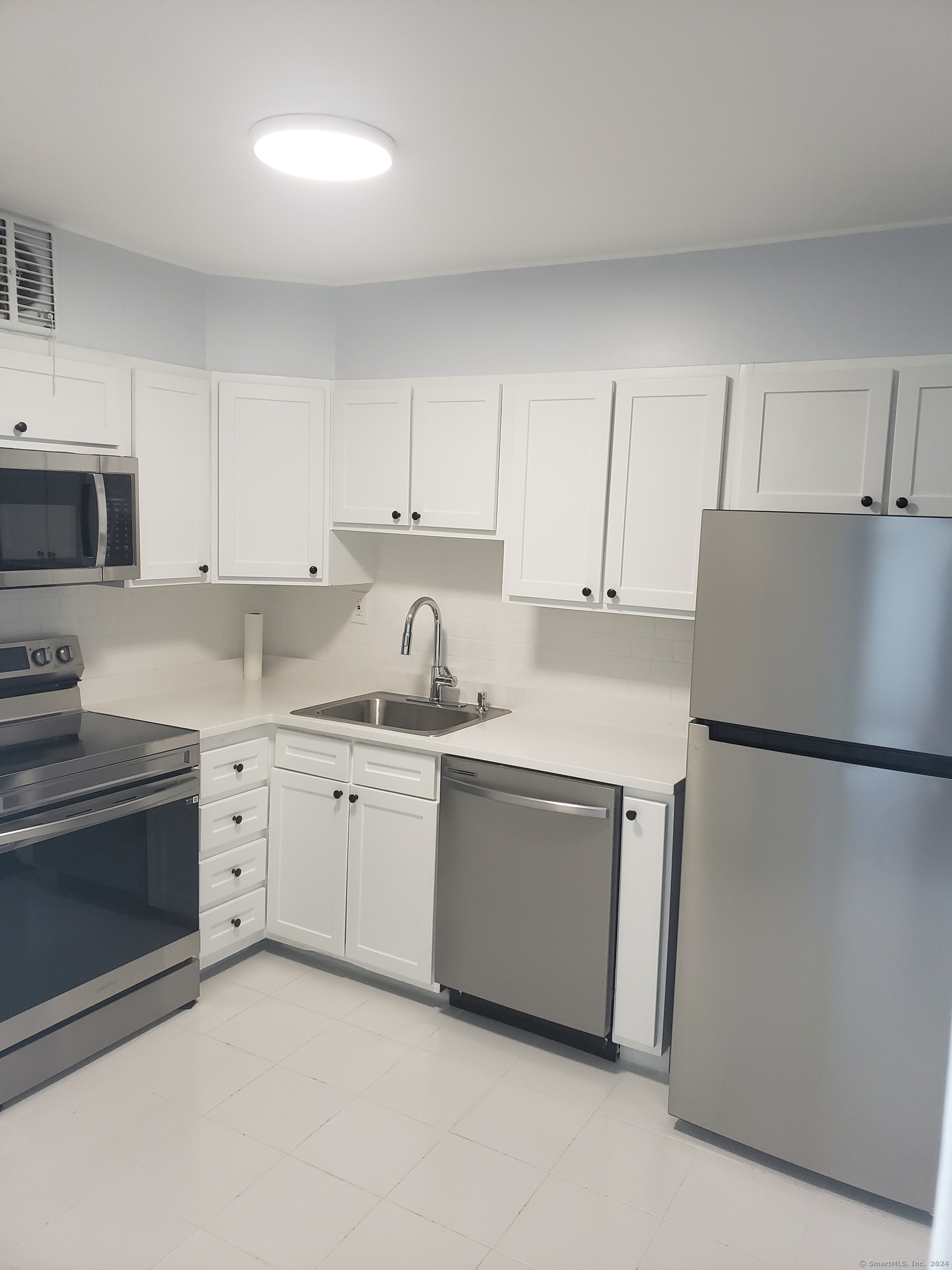 a kitchen with granite countertop white cabinets and white appliances