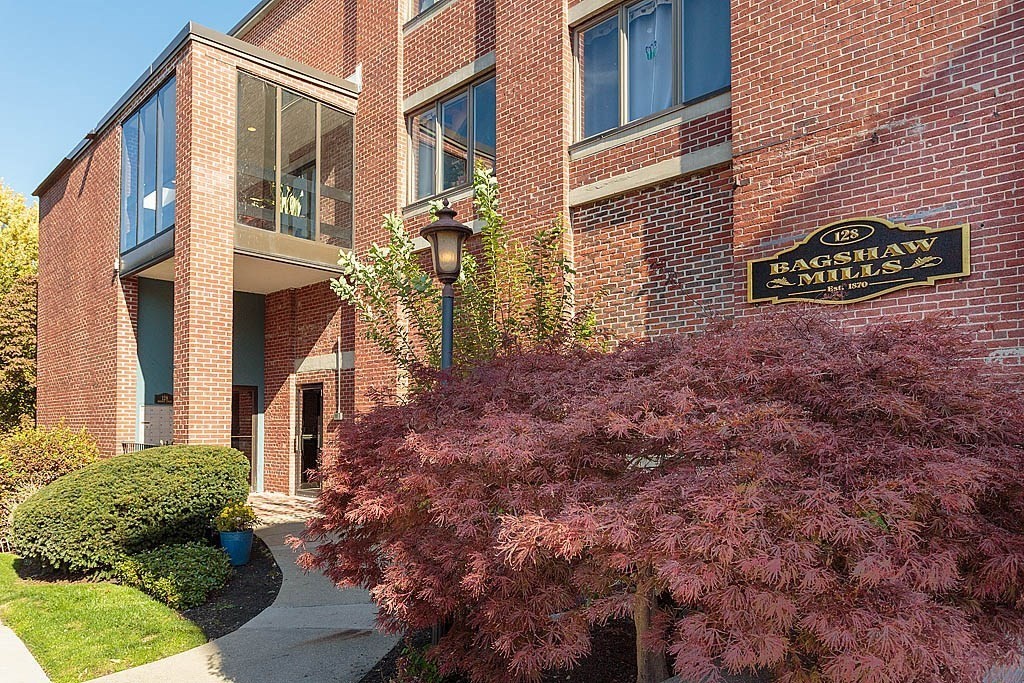 a view of a brick house with a yard and potted plants