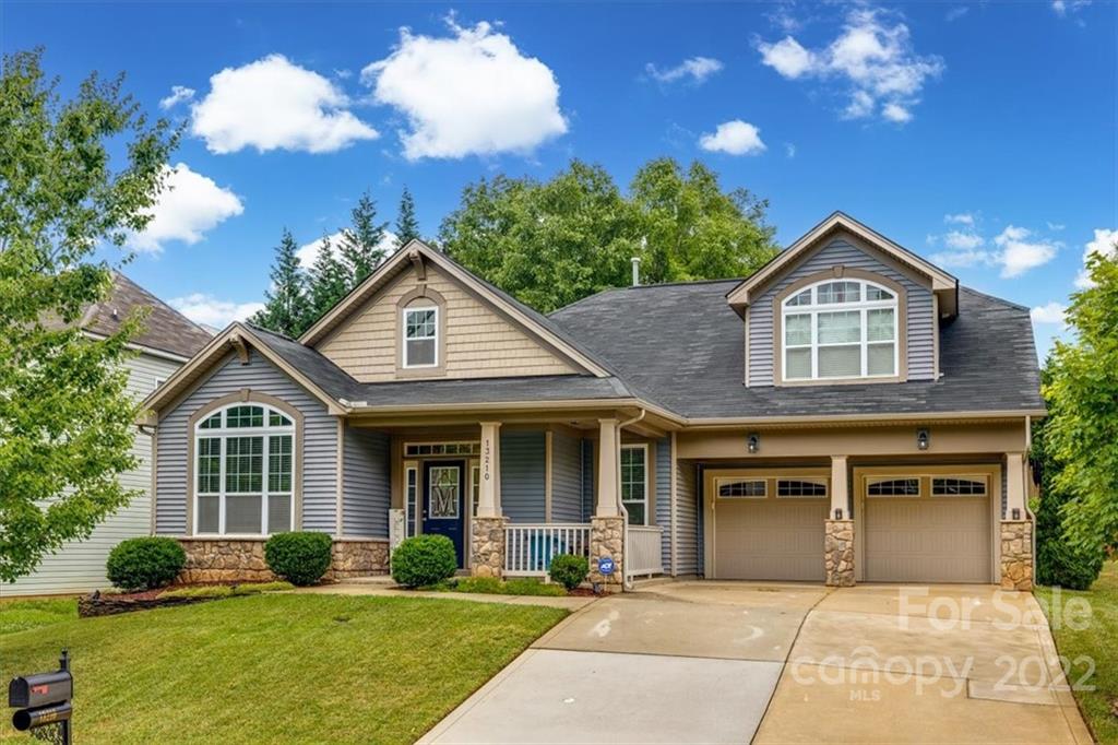 a front view of a house with yard and green space