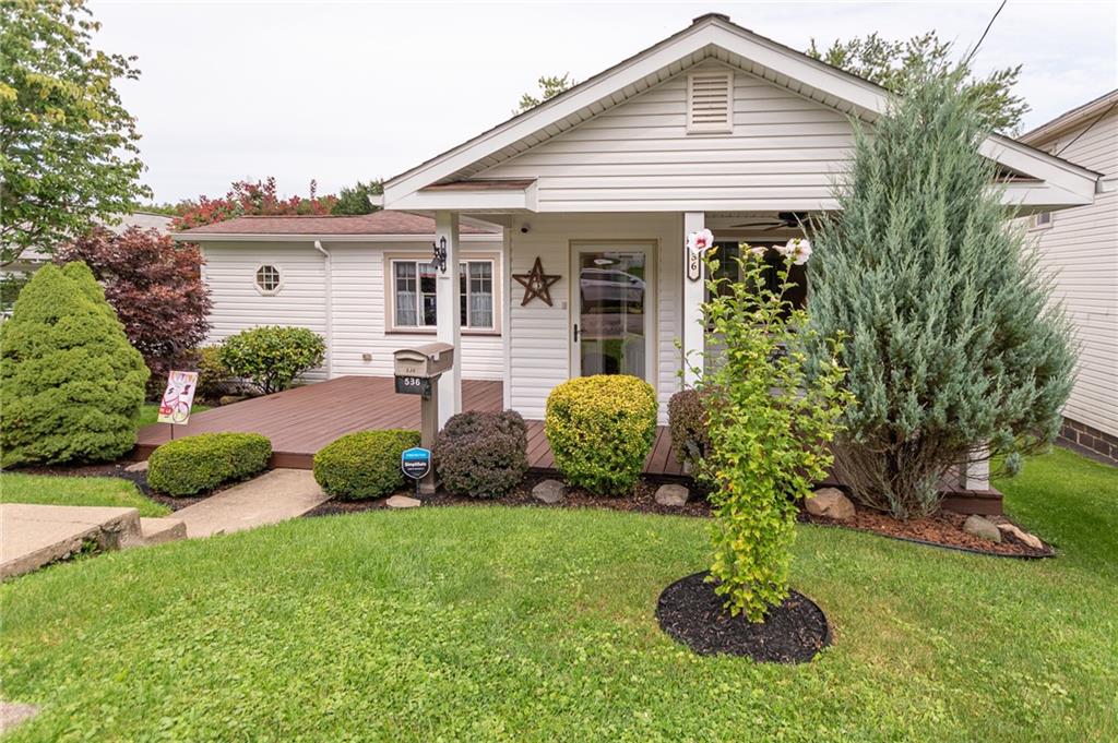 a front view of a house with a yard and potted plants