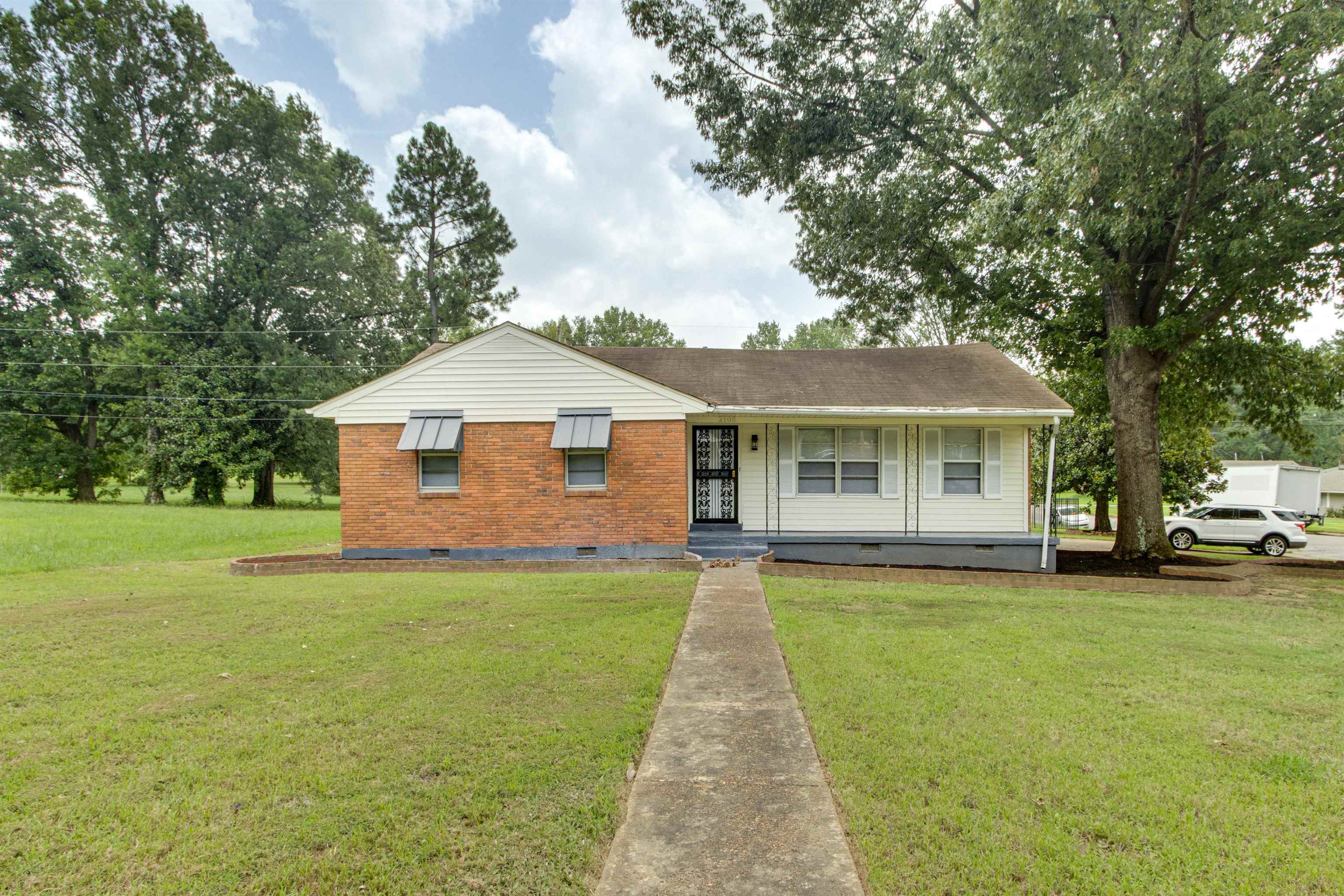 View of front of property featuring covered porch and a front lawn