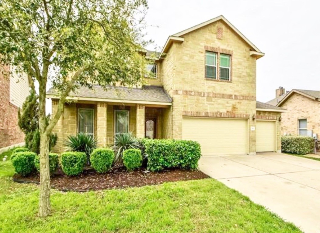 a front view of a house with a yard and garage