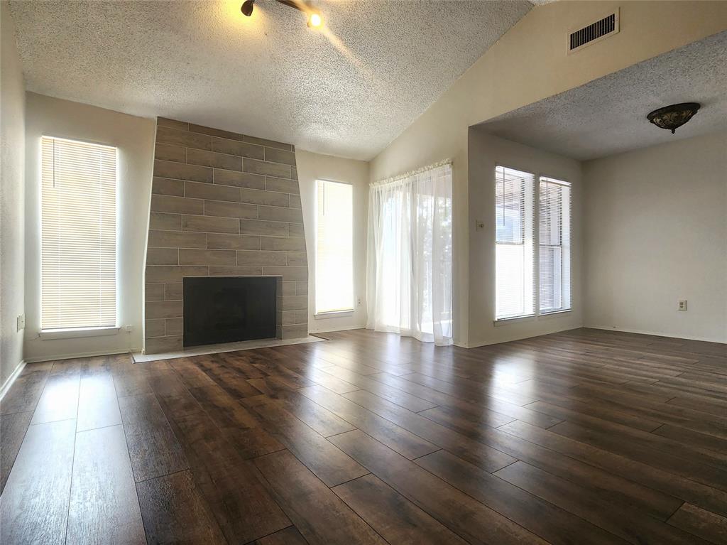 an empty room with wooden floor and fireplace