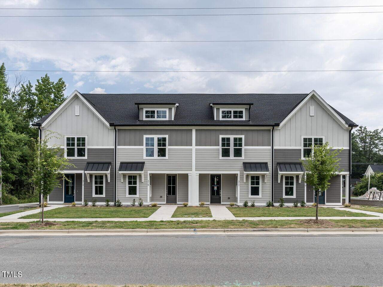 a view of houses with a big yard and large trees