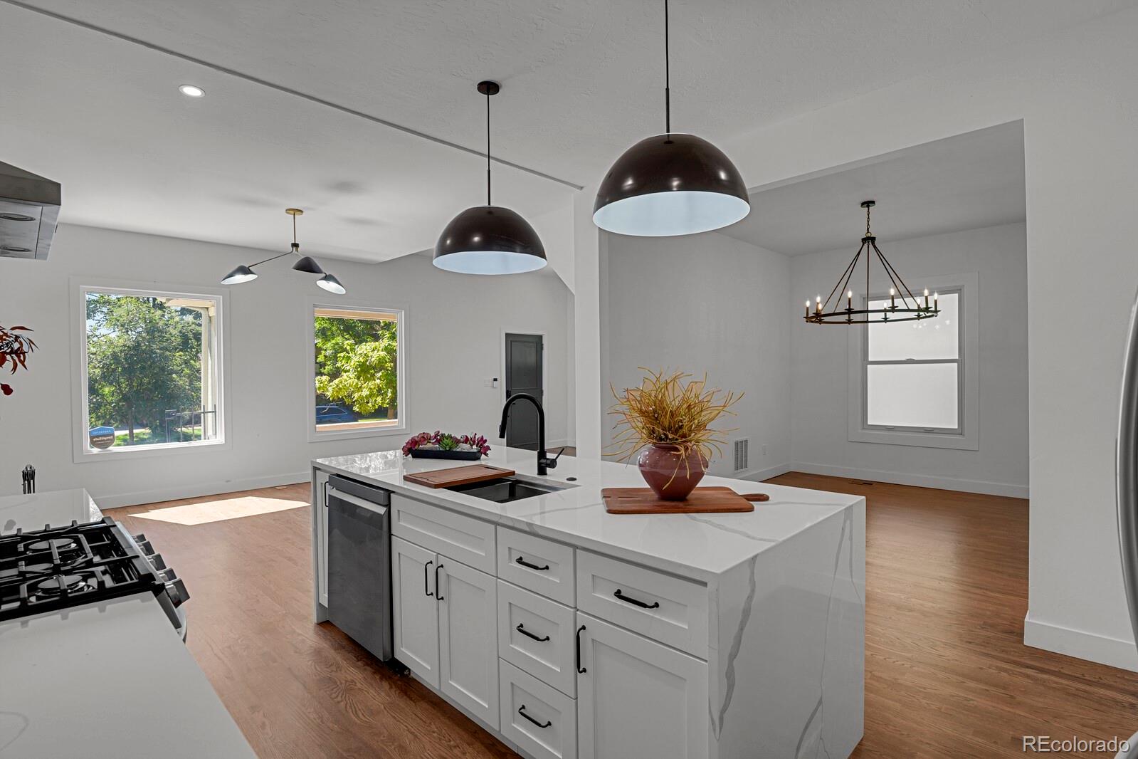 a kitchen with stainless steel appliances granite countertop a stove a sink and a window