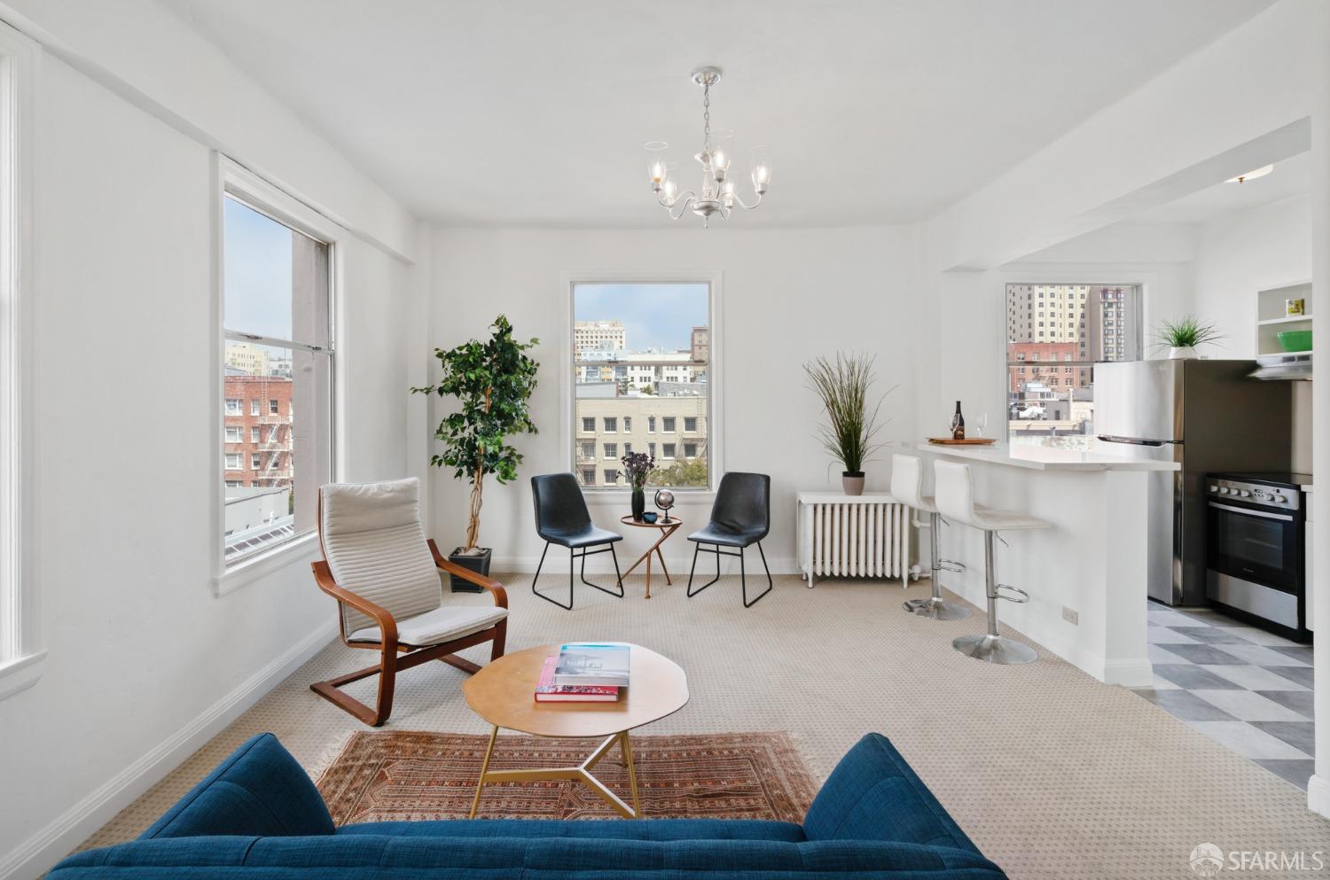 a living room with furniture a chandelier and a dining table