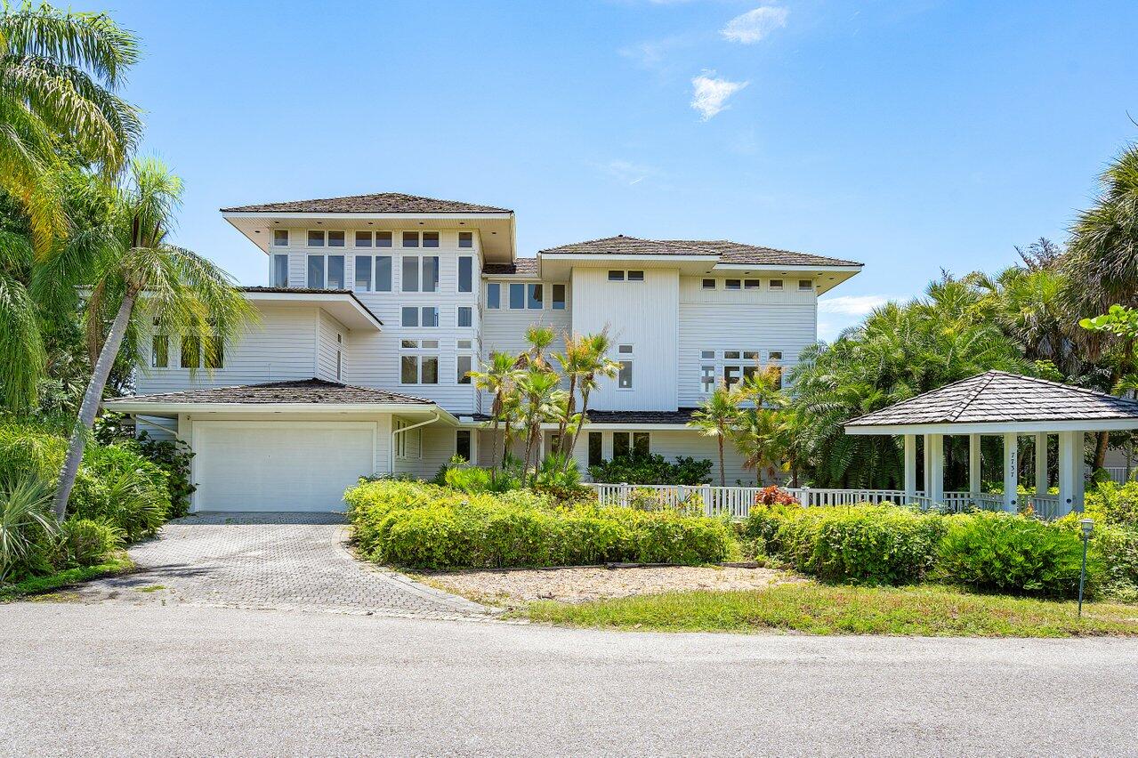 a front view of a house with plants and garage