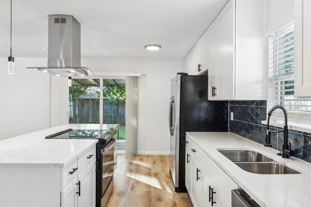 a kitchen with stainless steel appliances kitchen island granite countertop a sink refrigerator and cabinets