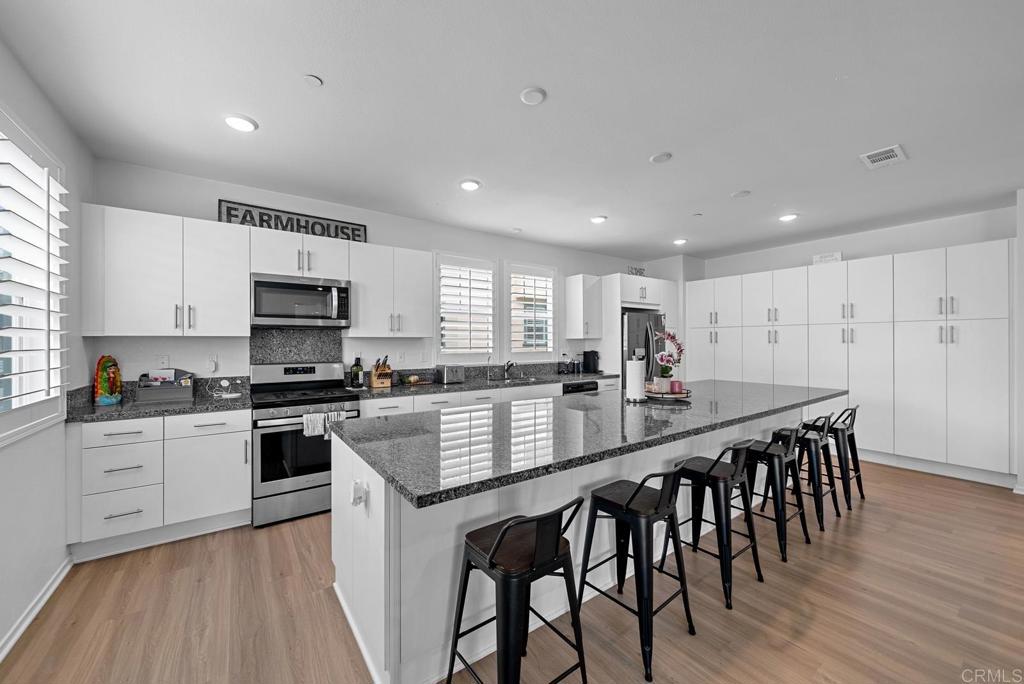 a large kitchen with kitchen island a table and chairs in it