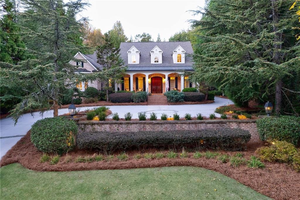 a front view of a house with a yard and potted plants