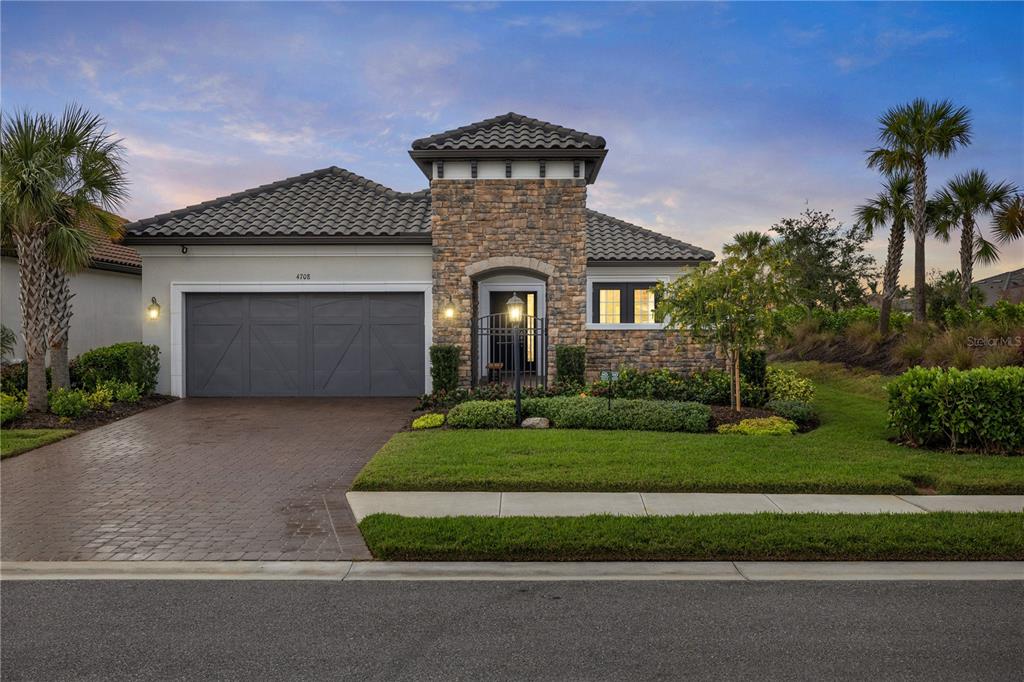 a front view of a house with a garden and garage