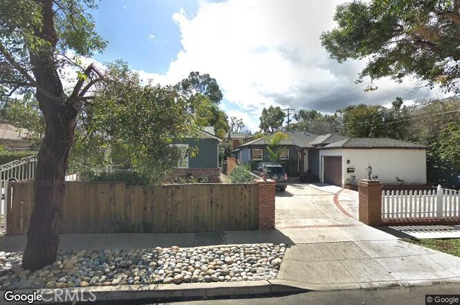 a view of a house with a wooden fence