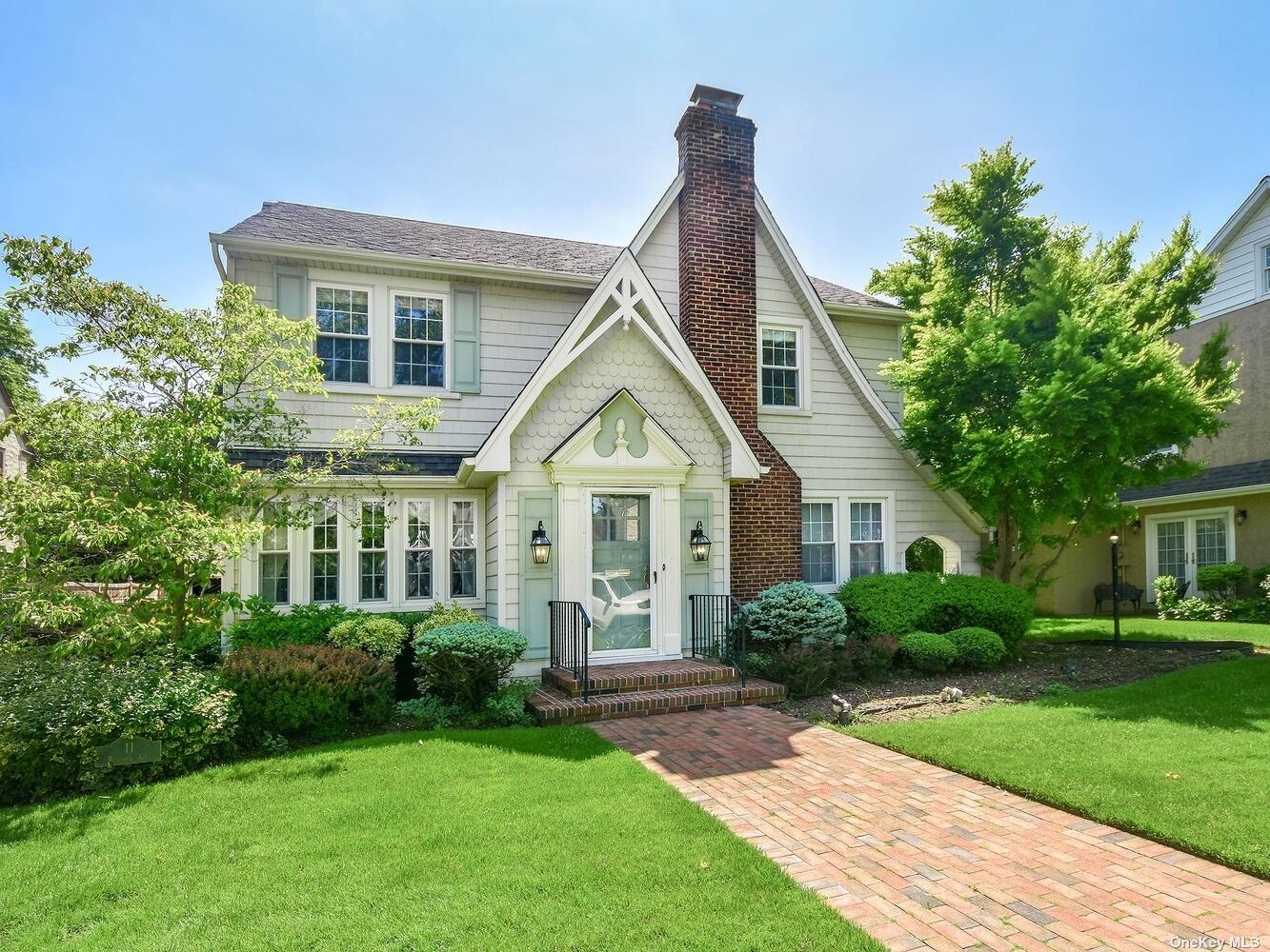 a front view of a house with a yard and potted plants