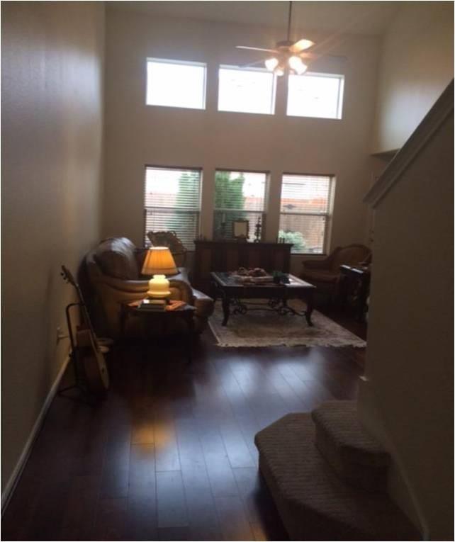 a living room with furniture window and a ceiling fan