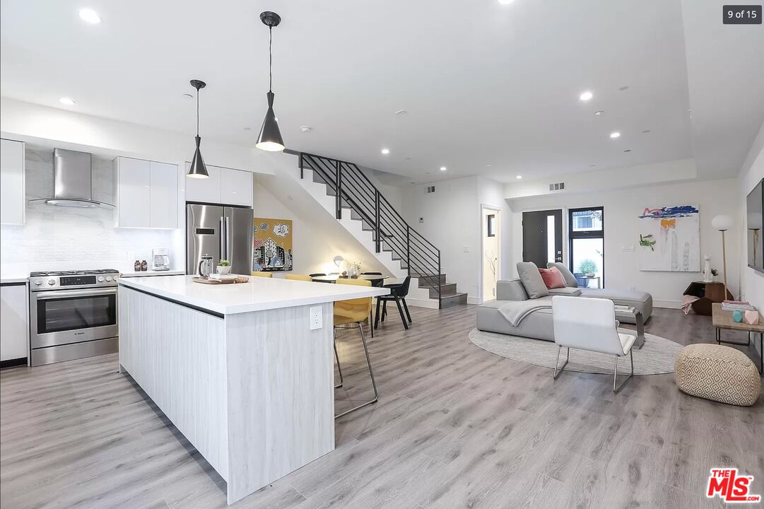 a kitchen with stainless steel appliances granite countertop wooden floors and white cabinets