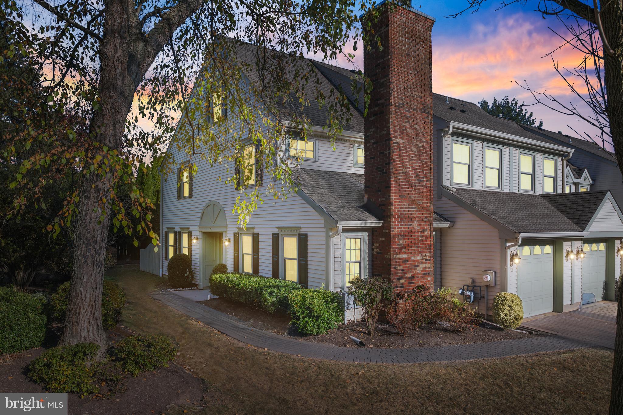 a front view of a house with yard and green space