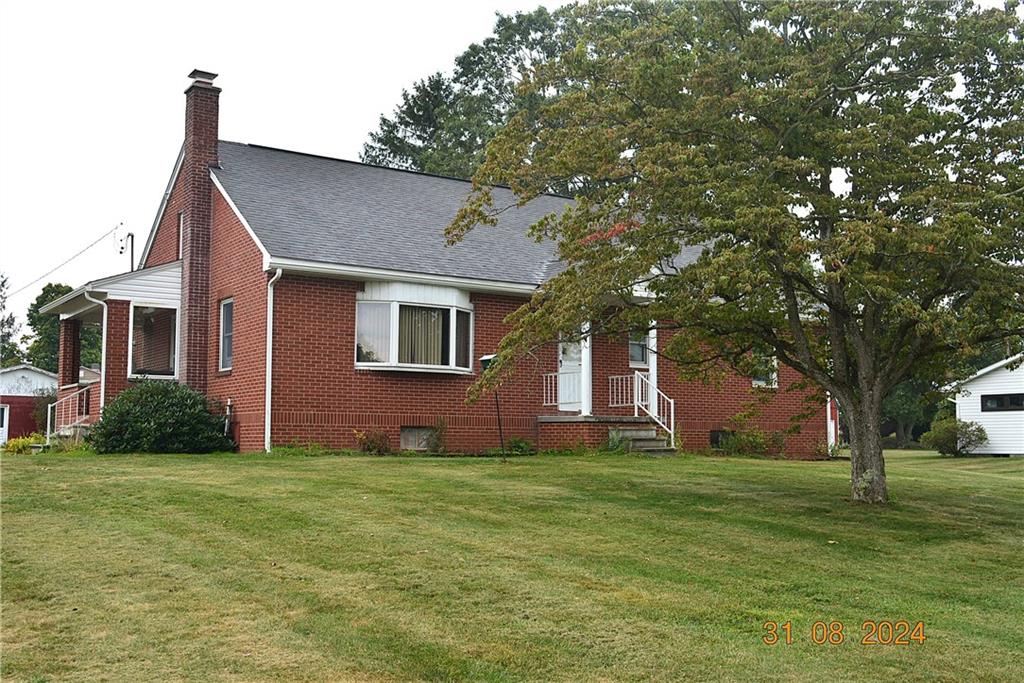 a front view of house with yard and trees