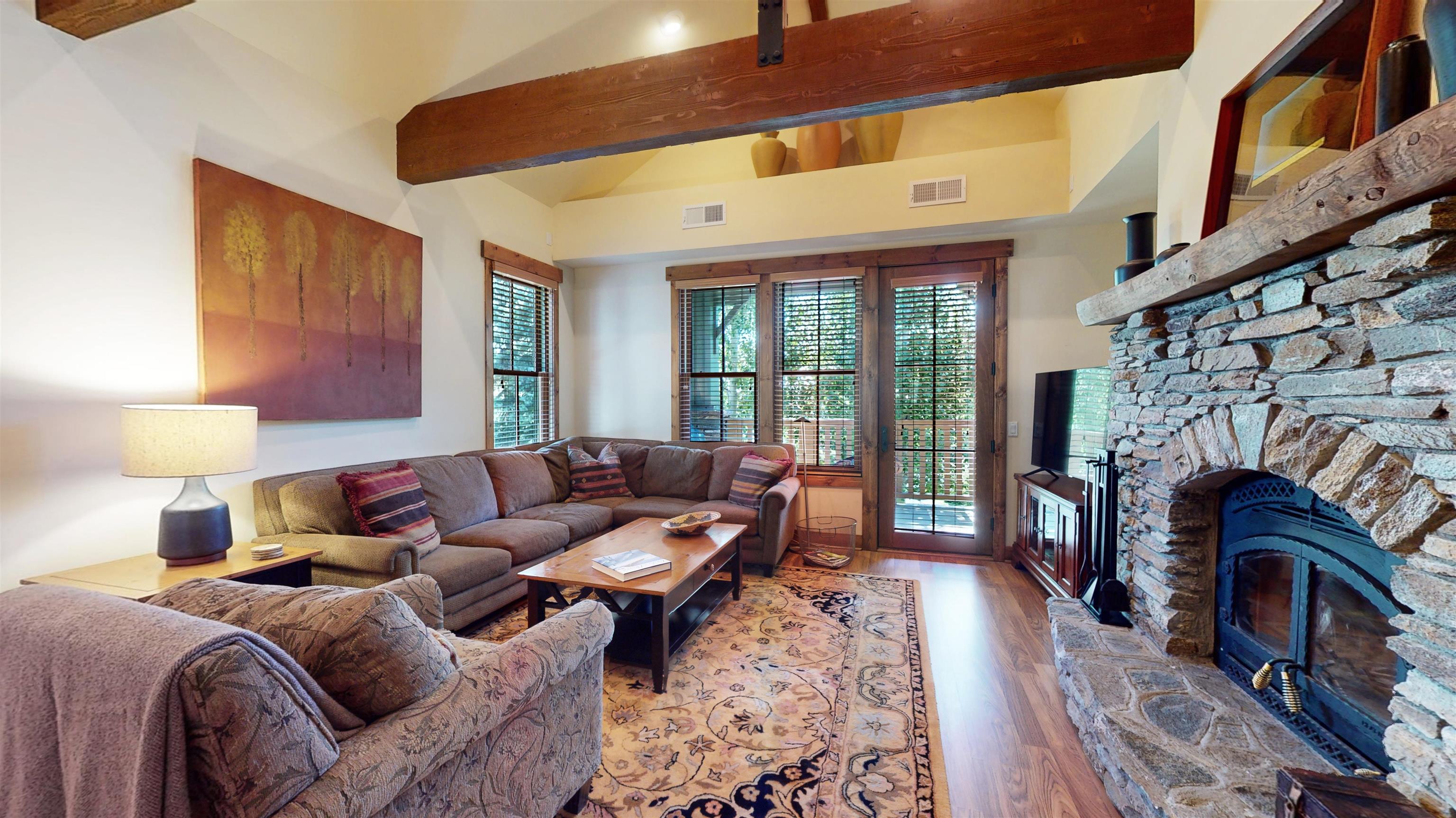 a living room with furniture a fireplace and a floor to ceiling window