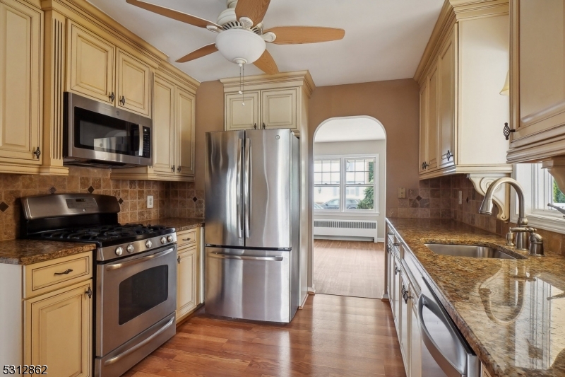 a kitchen with stainless steel appliances granite countertop a refrigerator a stove top oven a sink and dishwasher