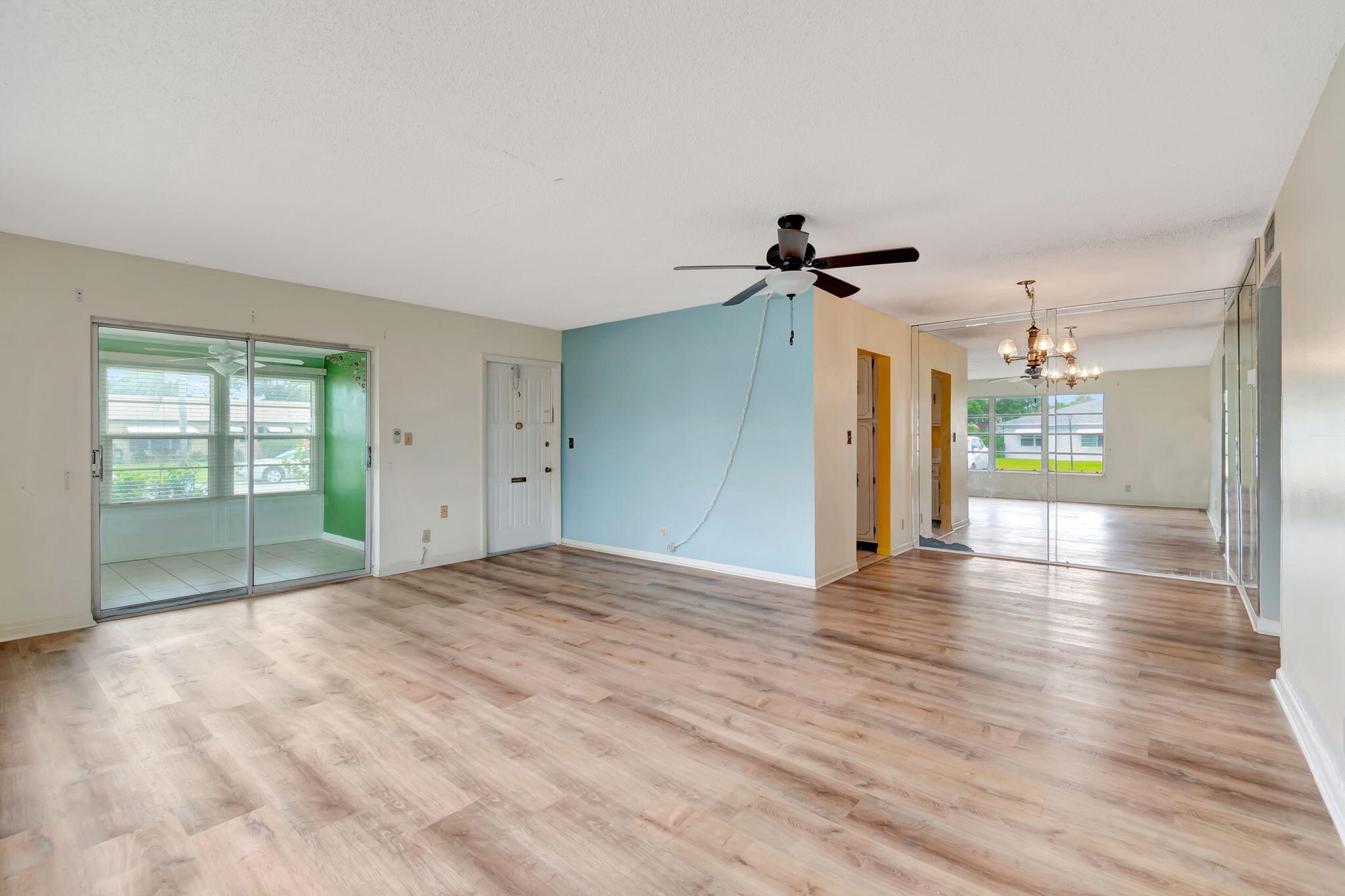 a view of a livingroom with wooden floor and a ceiling fan