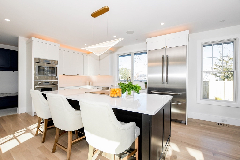 a kitchen with a dining table chairs and refrigerator