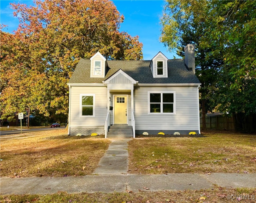 New england style home with a front lawn