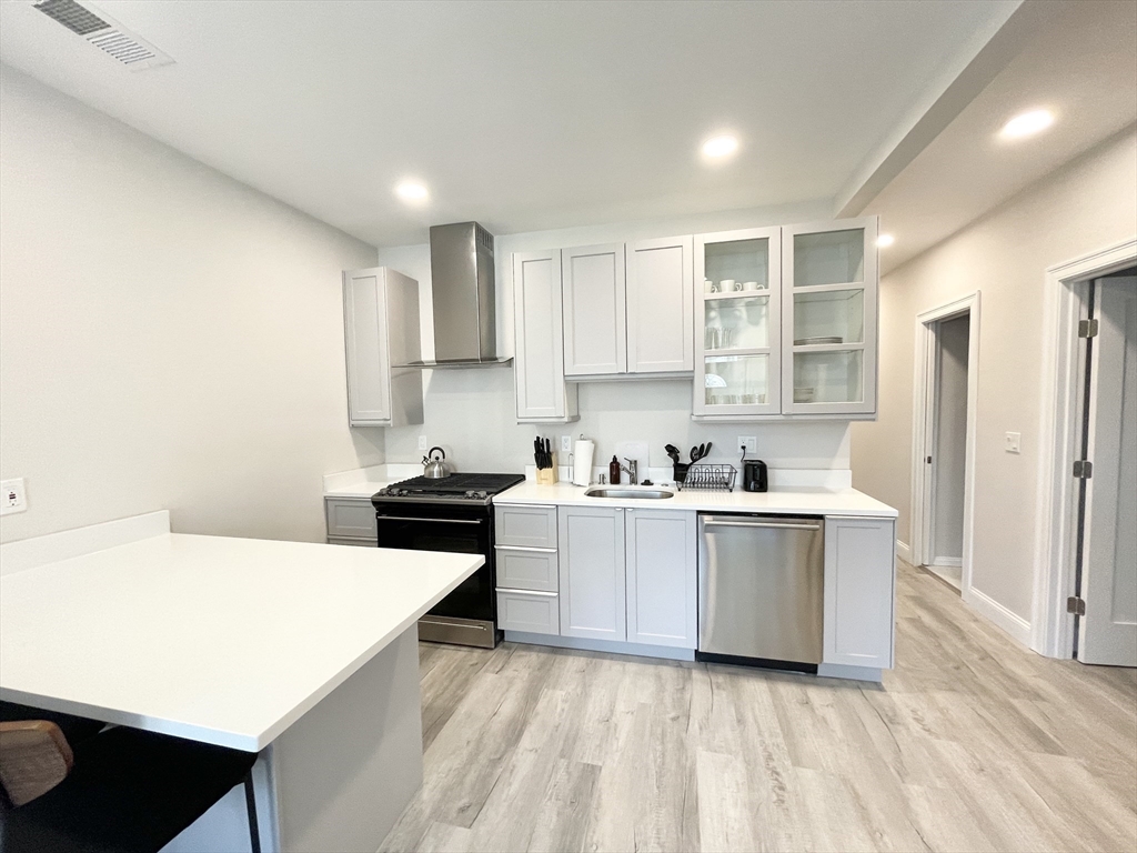 a kitchen with stainless steel appliances a white stove top oven sink and cabinets