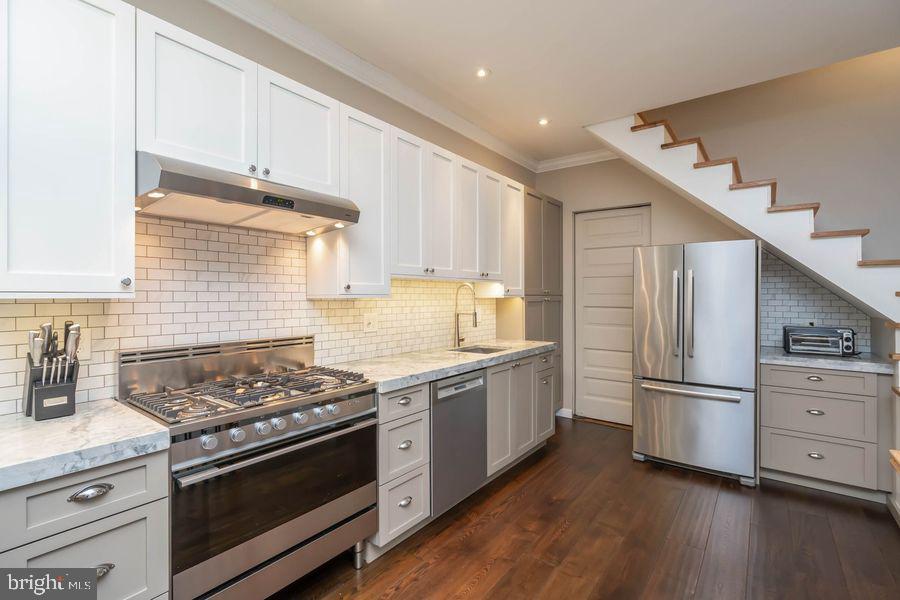 a kitchen with stainless steel appliances granite countertop a stove a refrigerator and a refrigerator