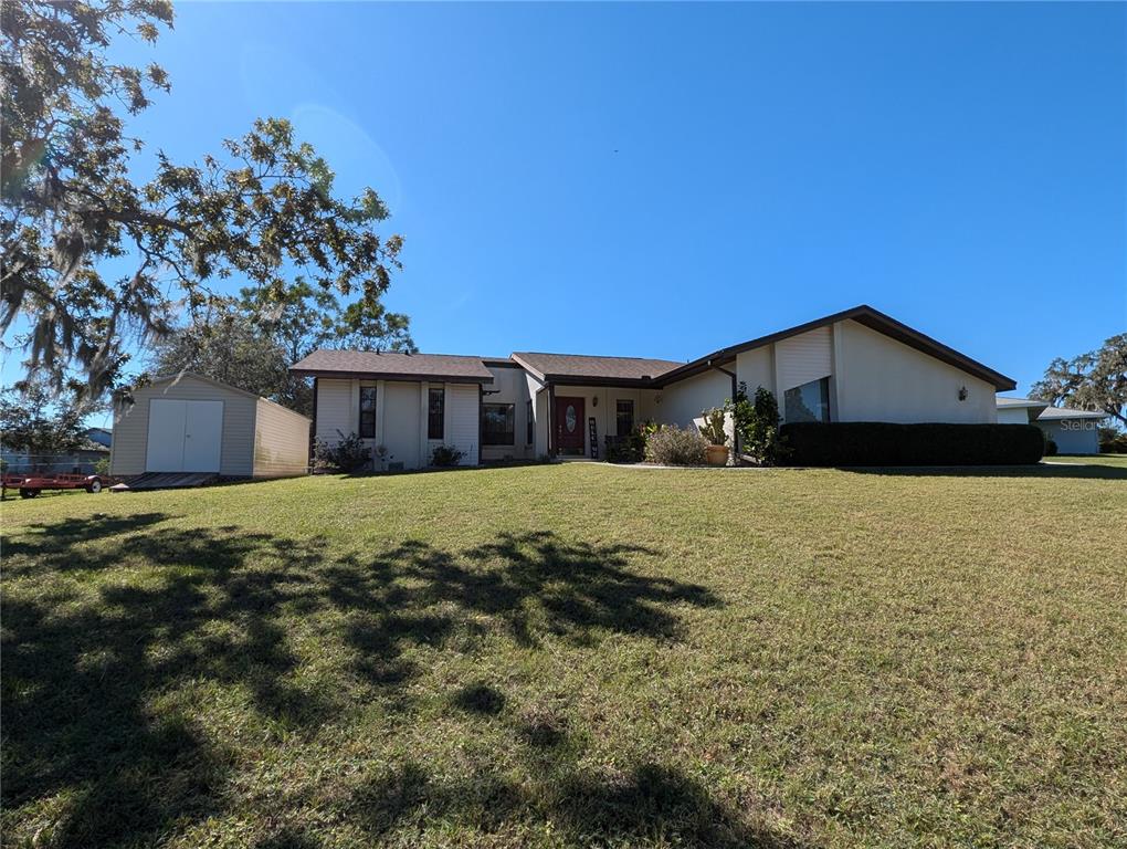 a front view of house with yard and trees in the background