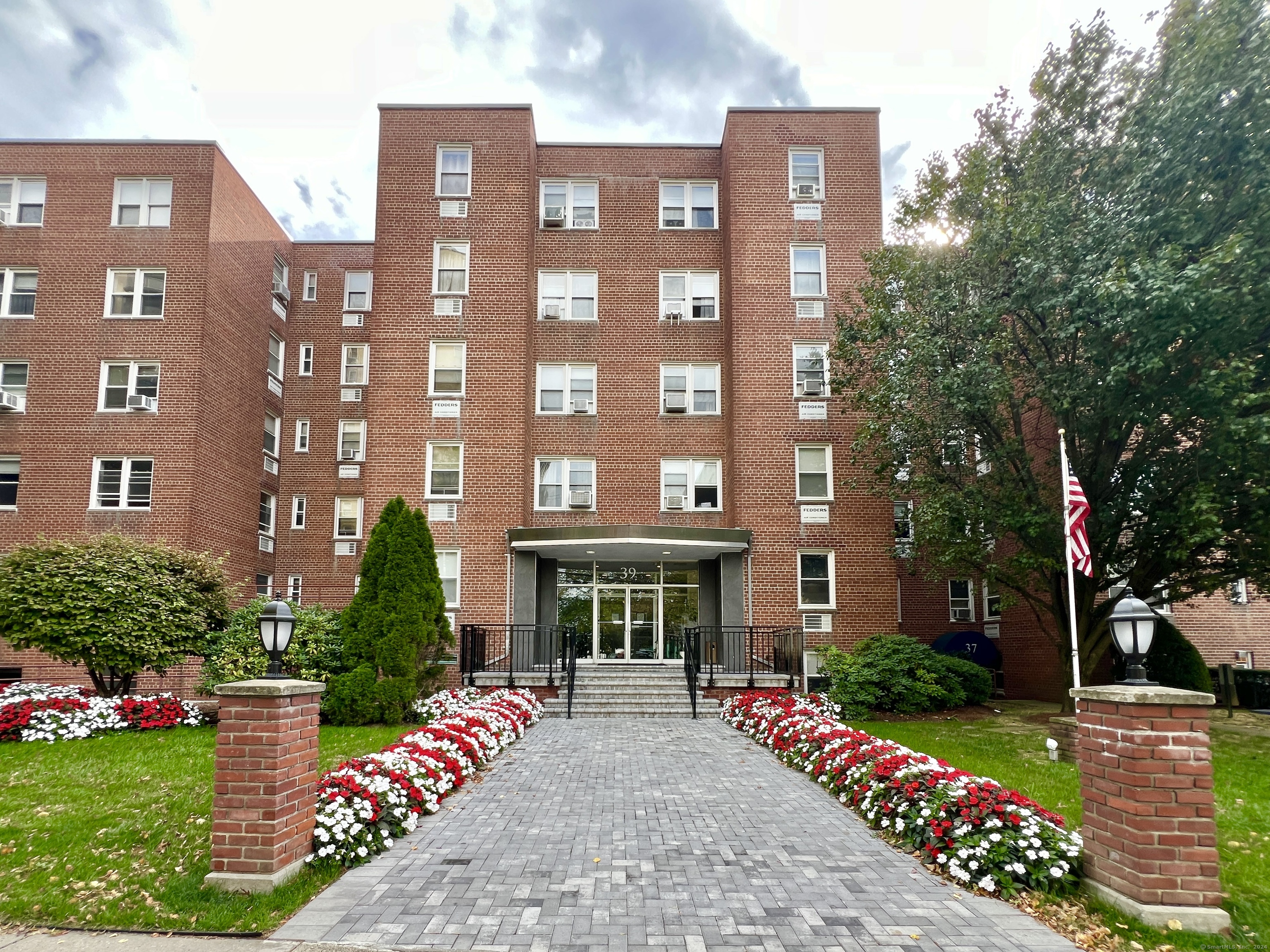 a front view of a multi story building with yard