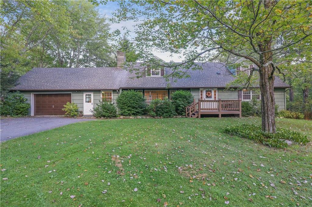 a view of a house with a yard and a large tree