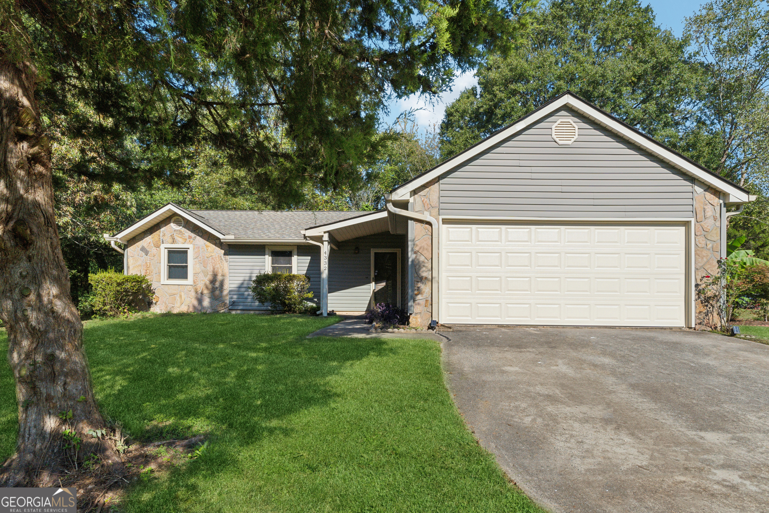 a front view of house with yard and trees in the background