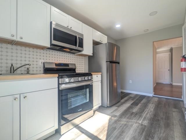 a kitchen with stainless steel appliances a stove microwave and a sink