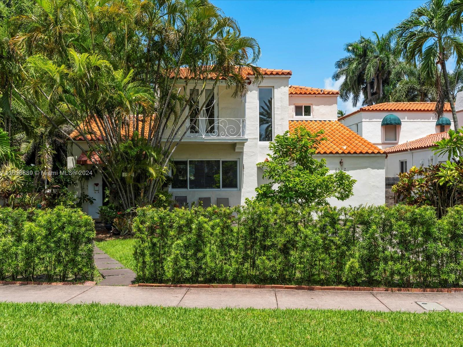 a view of a house with a yard and potted plants