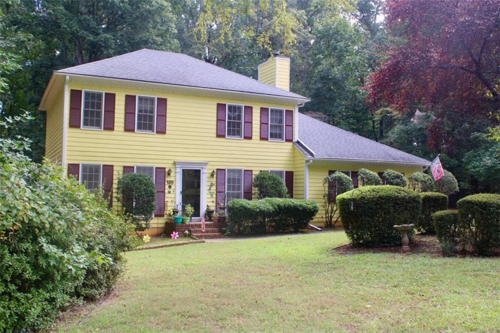 a view of a house with a backyard and sitting area