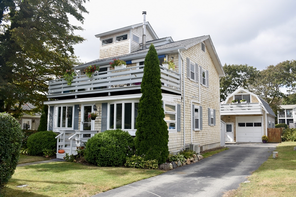 a front view of a house with a garden and trees