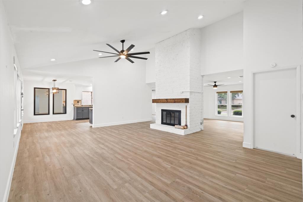 a view of an empty room with a fireplace and a window