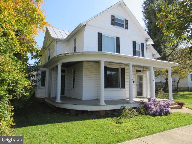 a front view of a house with a yard and potted plants