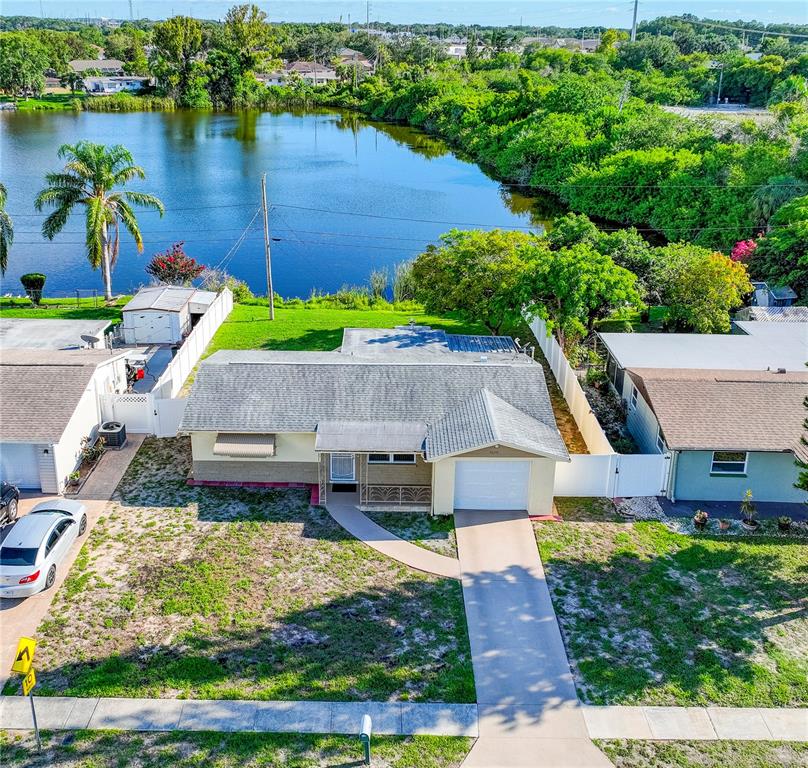 an aerial view of a house with a yard and lake view