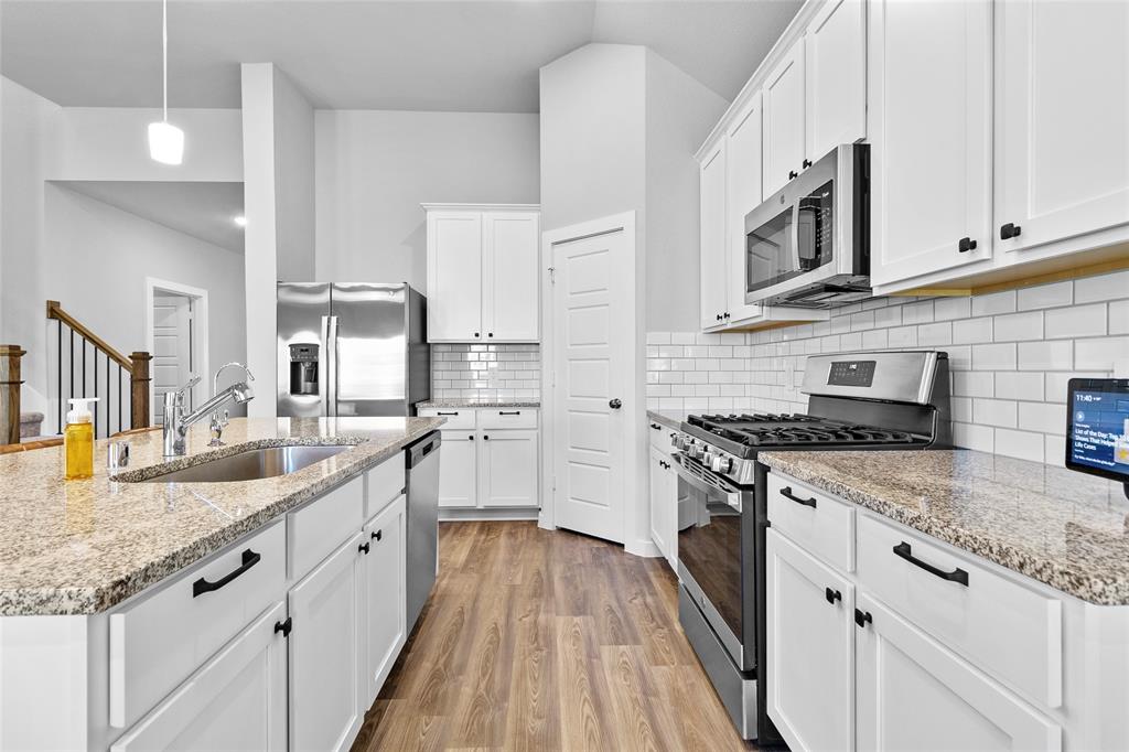 a kitchen with stainless steel appliances granite countertop a stove and a sink