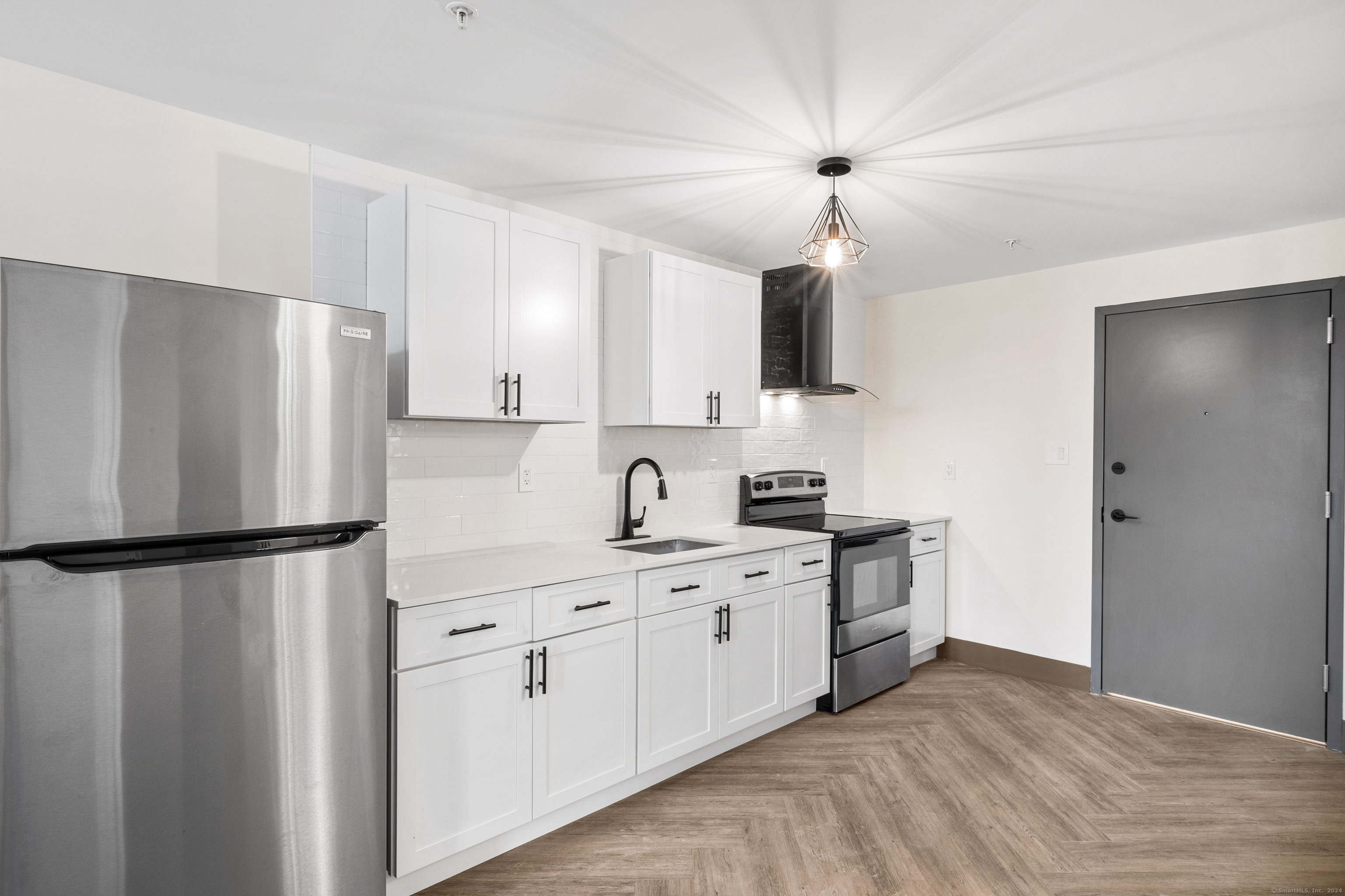 a kitchen with stainless steel appliances a refrigerator sink and white cabinets