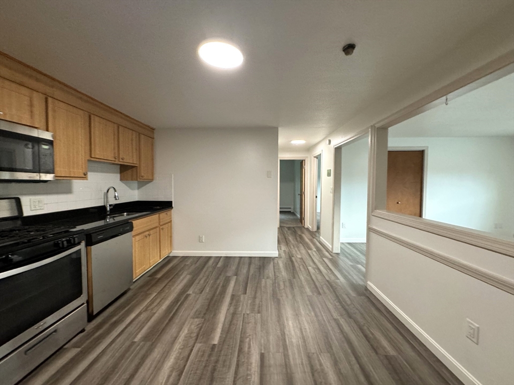 a kitchen with wooden floors and appliances